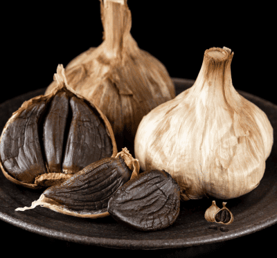 ALHO NEGRO Um Superalimento Milenar que Transforma a Sua Saúde Frequentemente, associamos o alho comum (branco e cru) aos seus inegáveis benefícios imunológicos. Todavia, existe um processo de maturação e fermentação ancestral capaz de elevar essas propriedades terapêuticas a um patamar biológico quase inigualável. Estamos falando do alho negro, uma iguaria de origem asiática que, muito além de entregar um sabor umami, adocicado e complexo, atua como um verdadeiro escudo protetor, sistêmico e celular para o seu organismo.